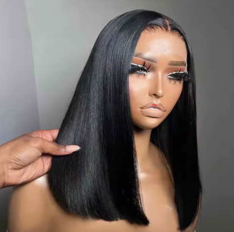 Mannequin head with a black wig on a plain background